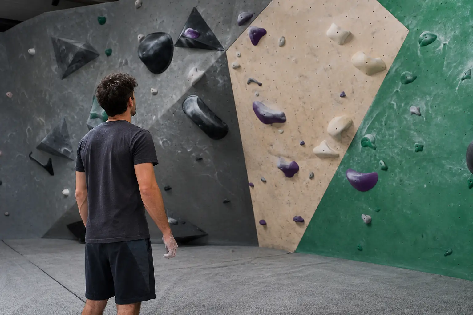Person studying a climbing wall route before starting